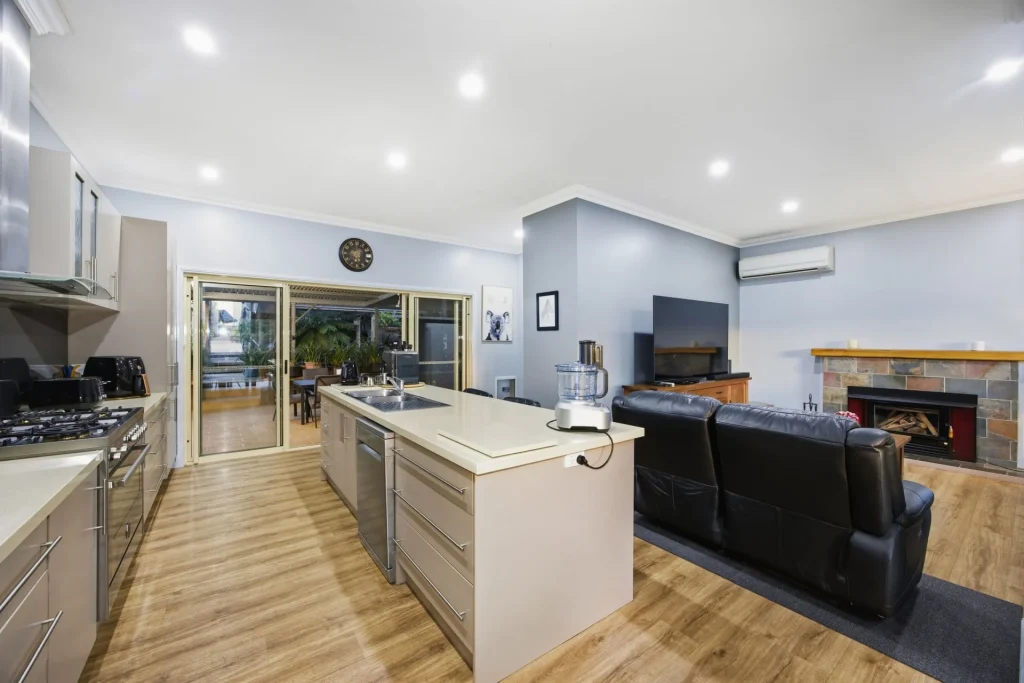 Modern open-plan kitchen and family living area with island bench.