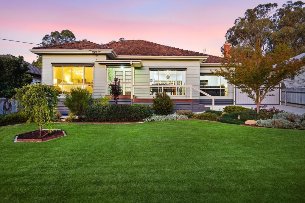 Front view of the immaculate family home at 27 Raglan Street, Yea, featuring landscaped gardens and manicured lawns.